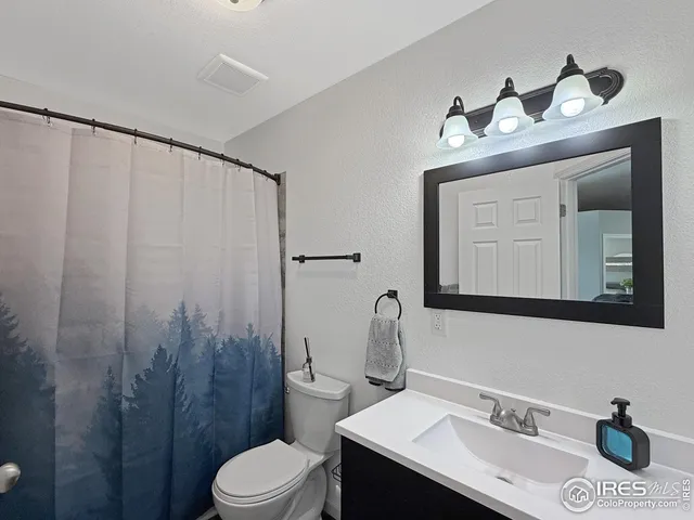 a bathroom with a sink vanity mirror and toilet