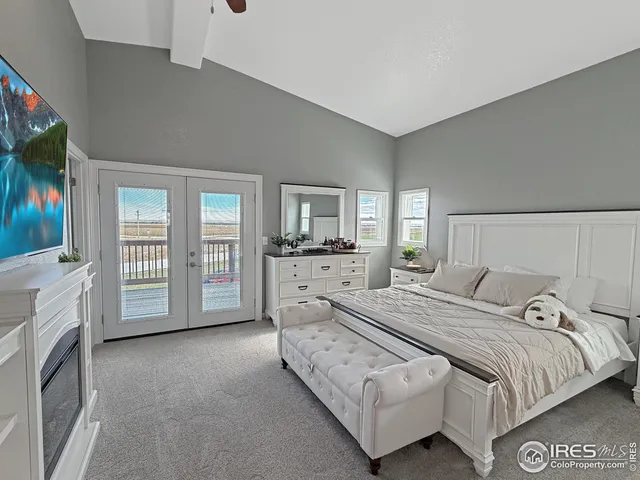 a spacious bedroom with a bed a flat screen tv and balcony view