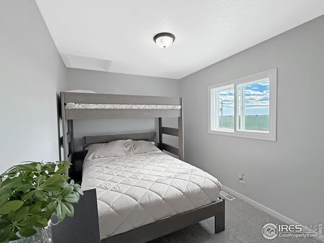 a bed sitting in a bedroom next to a window