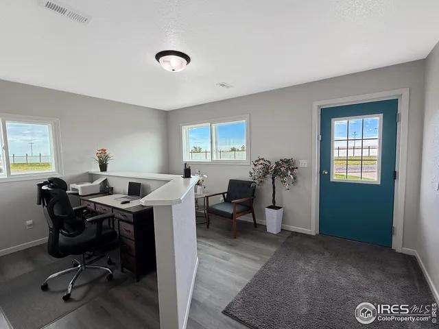 a view of a workspace with furniture and a window