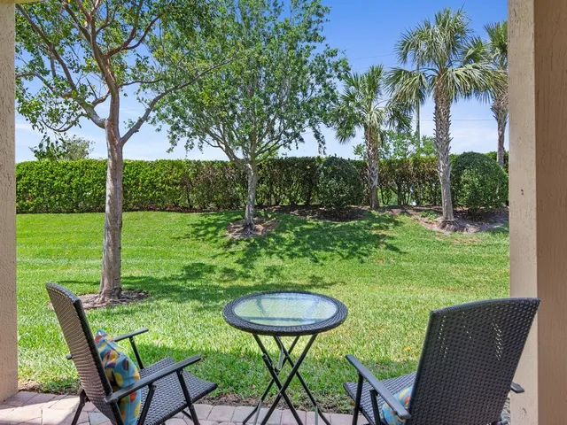 a view of a chairs and table in patio with a yard