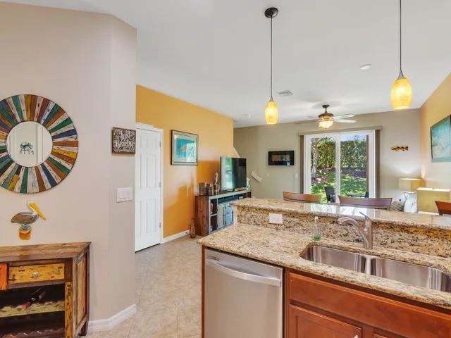 a kitchen with stainless steel appliances granite countertop a sink and a wooden floor