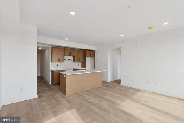 a large white kitchen with kitchen island a sink stainless steel appliances and cabinets