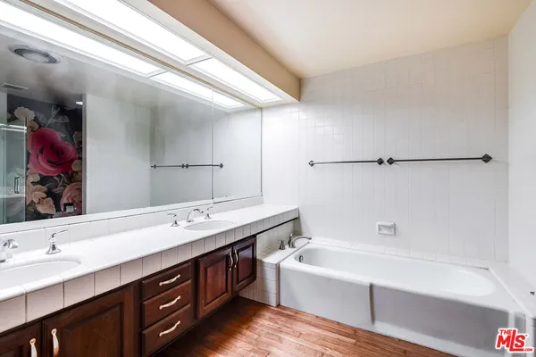 a bathroom with a tub sink and mirror