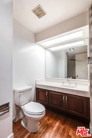 a bathroom with a toilet a sink and mirror