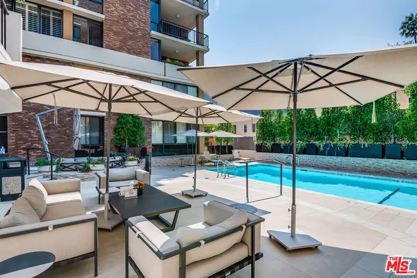 a view of a patio with a table and chairs under an umbrella