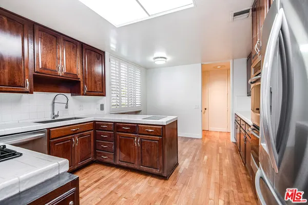 a kitchen with wooden cabinets and wooden floors