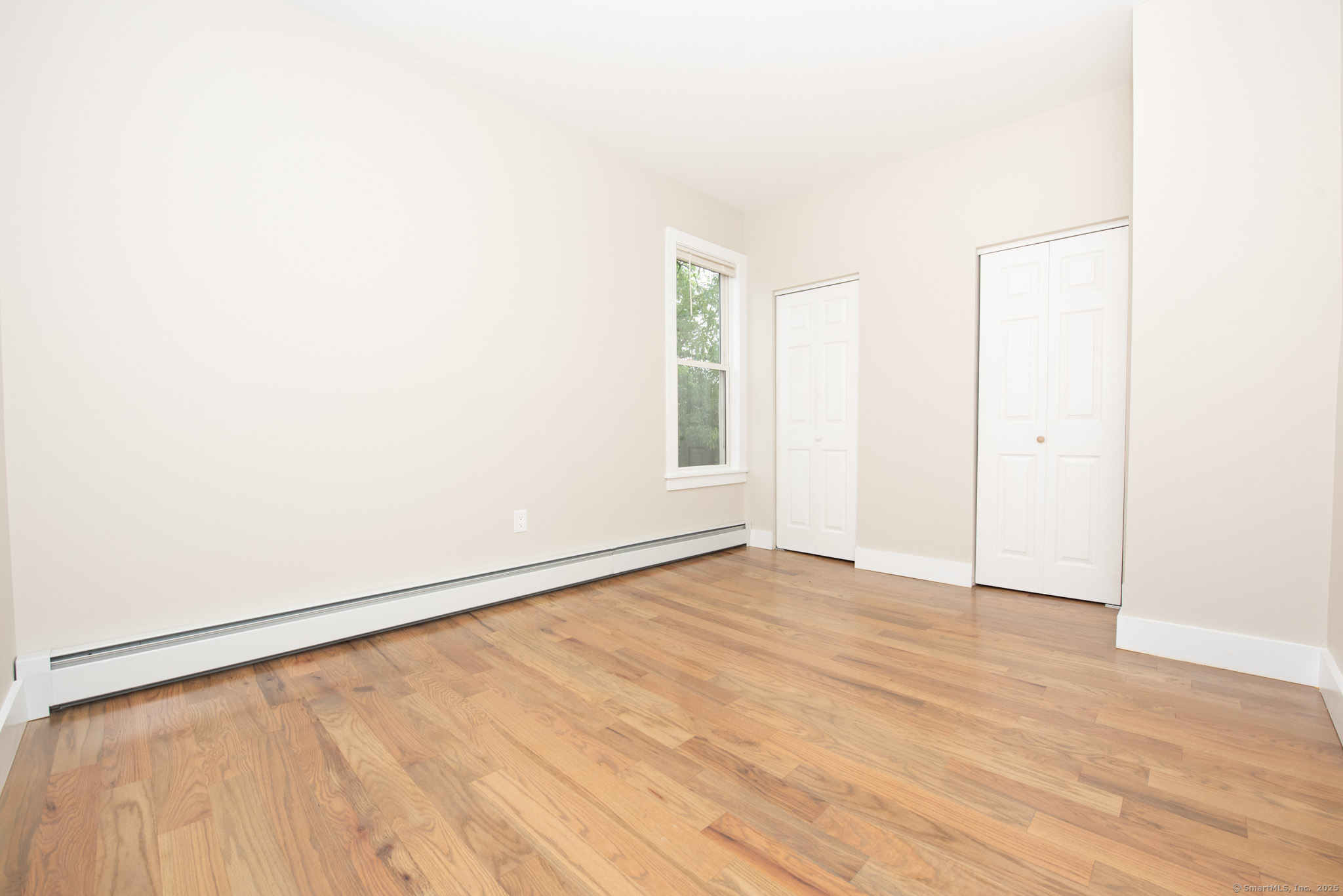 527 East Main Street Bridgeport, CT 06608 - Photo 12 of 25 a view of an empty room with wooden floor