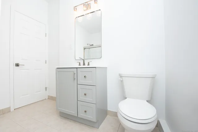 a bathroom with a toilet a sink and mirror