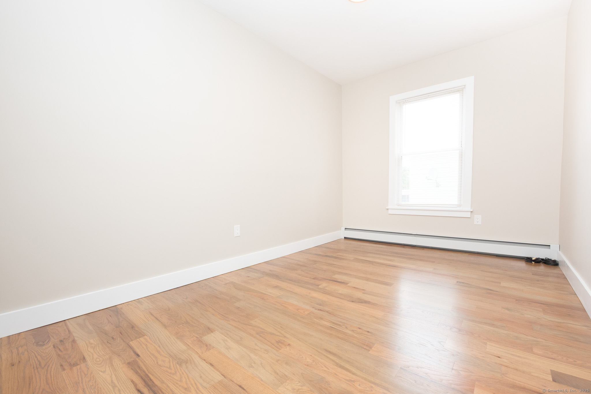 527 East Main Street Bridgeport, CT 06608 - Photo 20 of 25 an empty room with wooden floor and windows