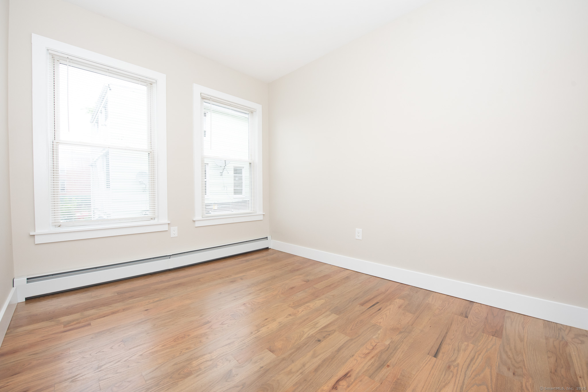 527 East Main Street Bridgeport, CT 06608 - Photo 22 of 25 an empty room with wooden floor and windows