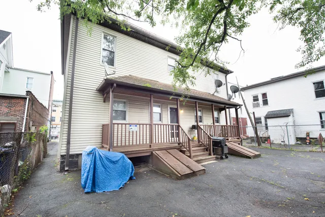 a view of a chair and table in the back yard of the house