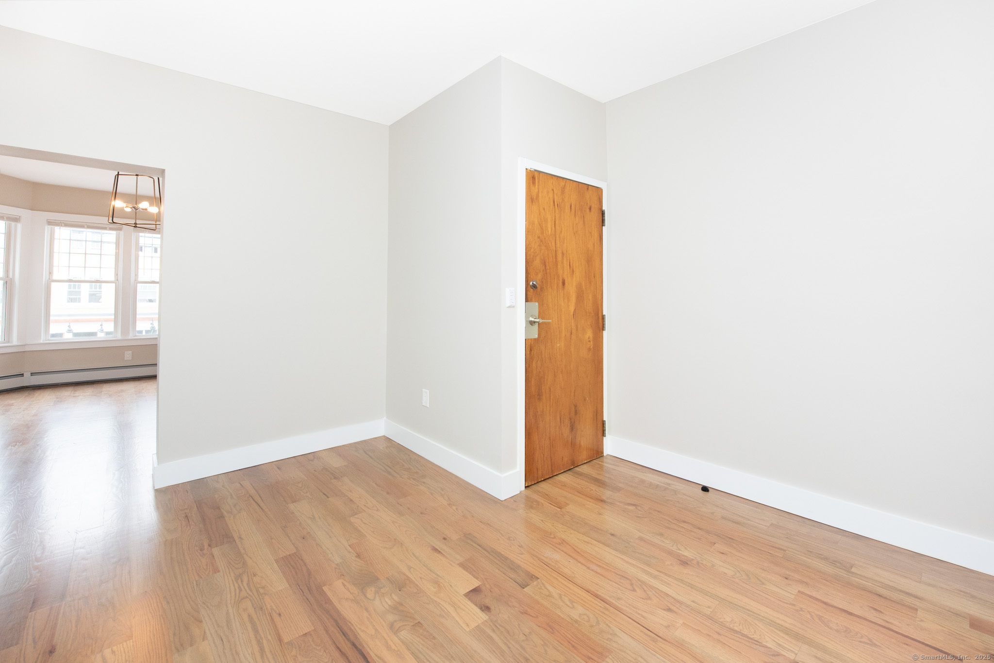 527 East Main Street Bridgeport, CT 06608 - Photo 10 of 25 a view of an empty room with wooden floor and a window