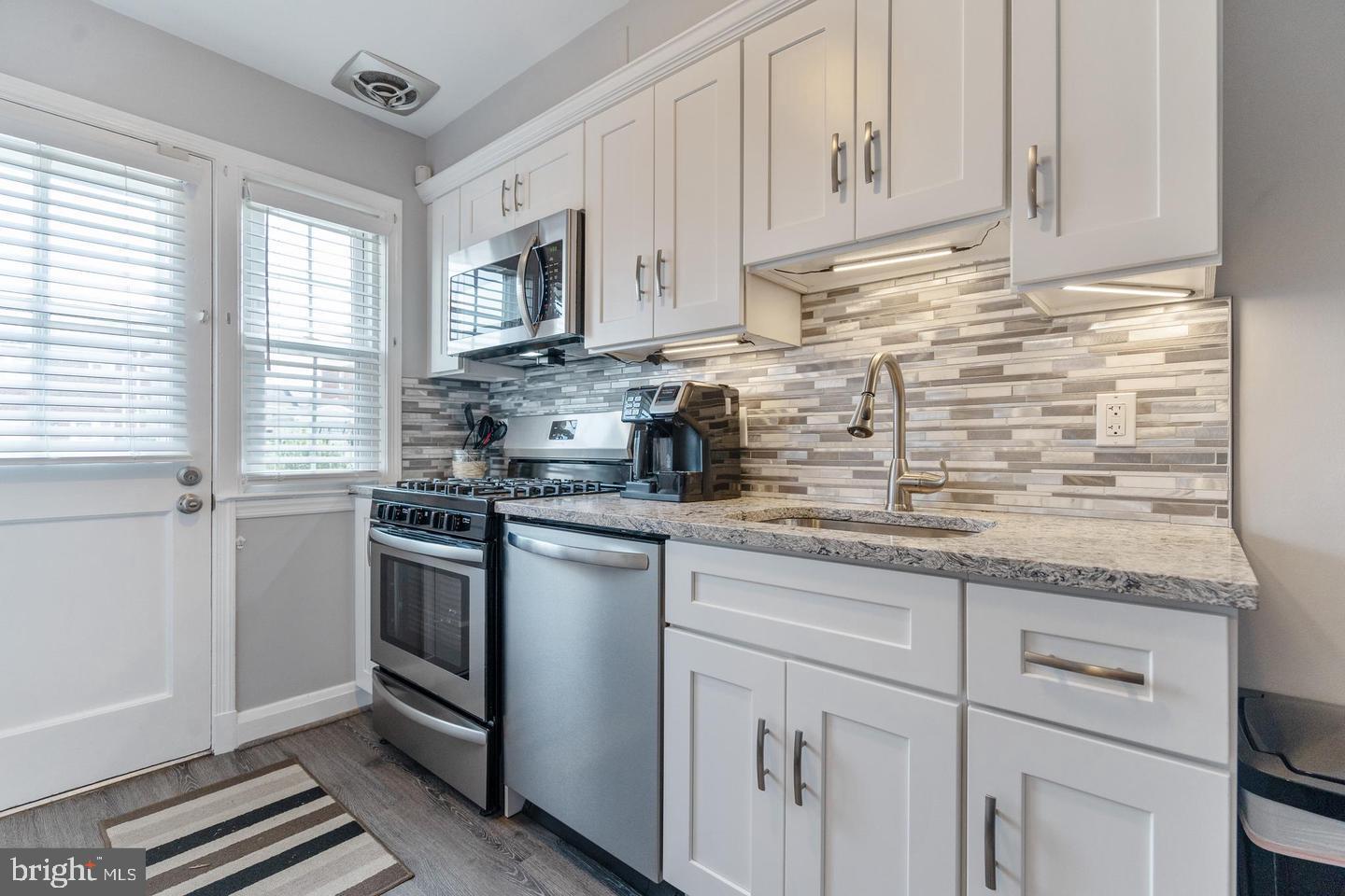 1067 Elm Road Halethorpe, MD 21227 - Photo 12 of 32 a kitchen with granite countertop white cabinets and white appliances