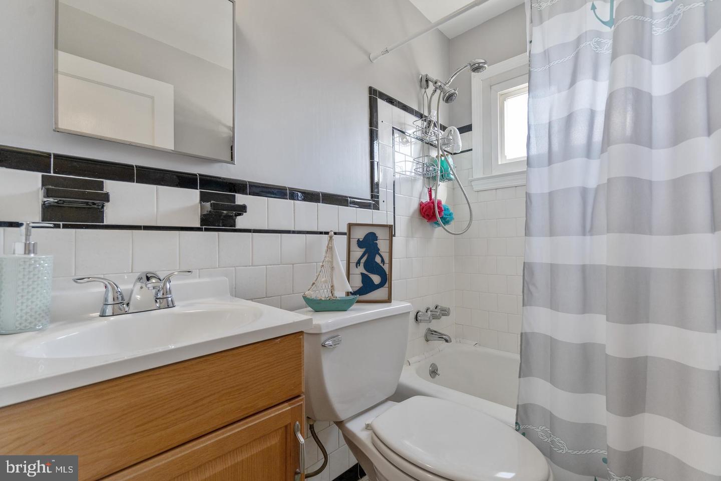 1067 Elm Road Halethorpe, MD 21227 - Photo 30 of 32 a bathroom with a sink a toilet and shower curtain