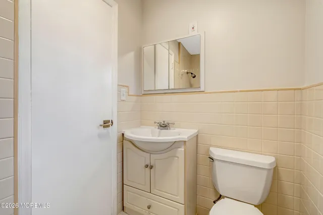 a bathroom with a sink mirror toilet and a mirror