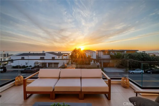a view of a roof deck with couches and sky view
