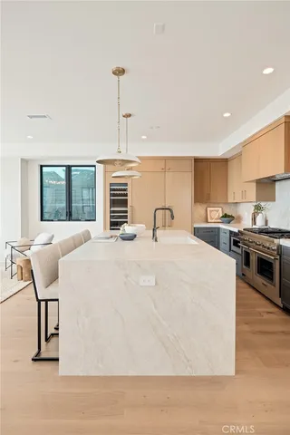 a kitchen with a stove a refrigerator and a dining table with wooden floor