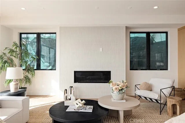 a living room with fireplace furniture and a dining table with kitchen view