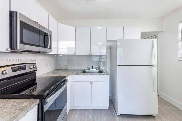 a kitchen with a refrigerator stove and microwave