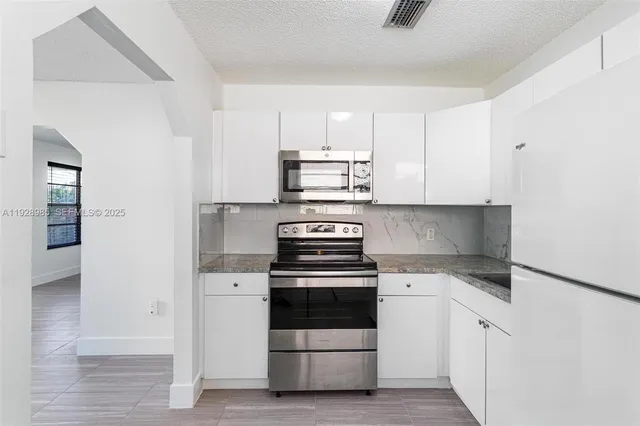 a kitchen with white cabinets and white appliances