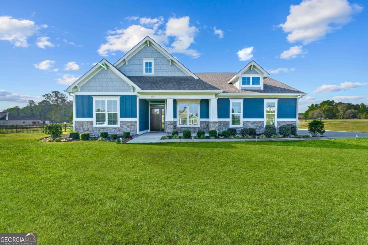 a front view of a house with a yard and potted plants