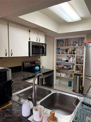 a kitchen with a sink stainless steel appliances and a counter top space