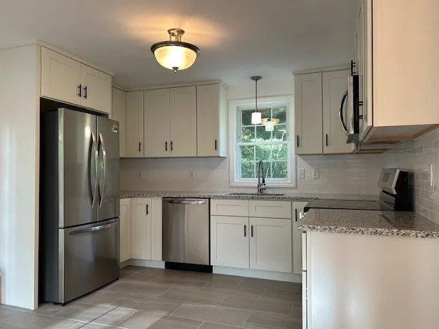 a kitchen with stainless steel appliances granite countertop a refrigerator sink and stove