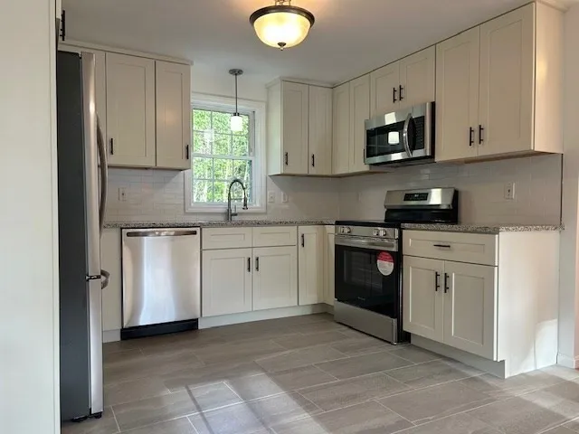 a kitchen with white cabinets stainless steel appliances and sink