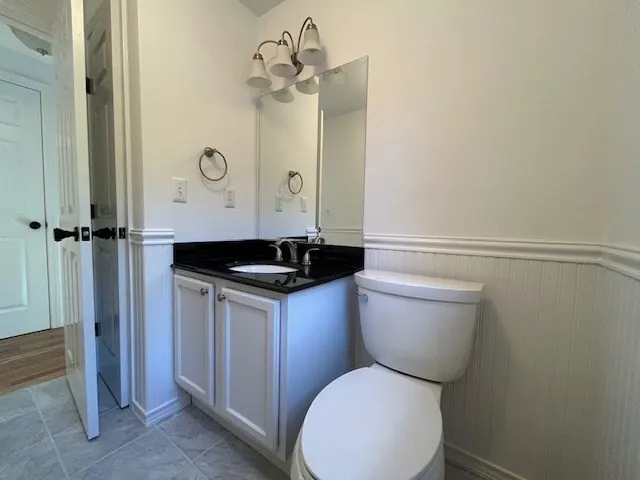 a bathroom with a granite countertop toilet sink and mirror