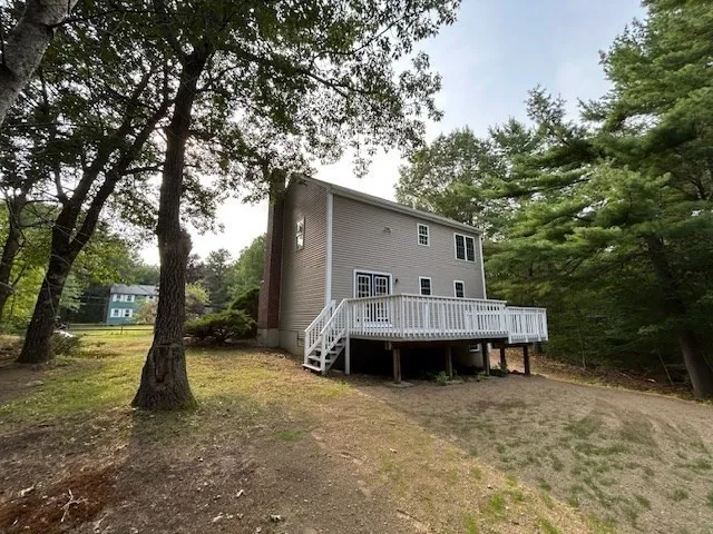 a view of house with backyard and trees
