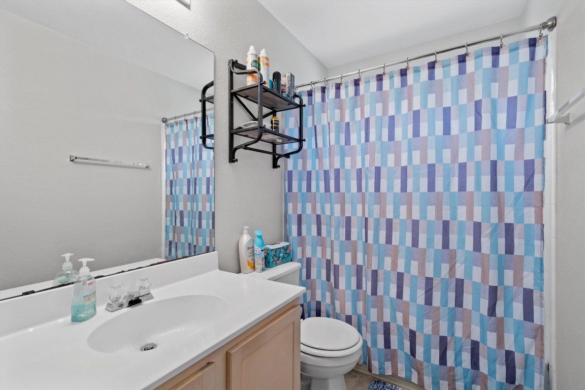 2601 Turtle River Drive Leander, TX 78641 - Photo 21 of 32 a bathroom with a sink a toilet and shower curtain