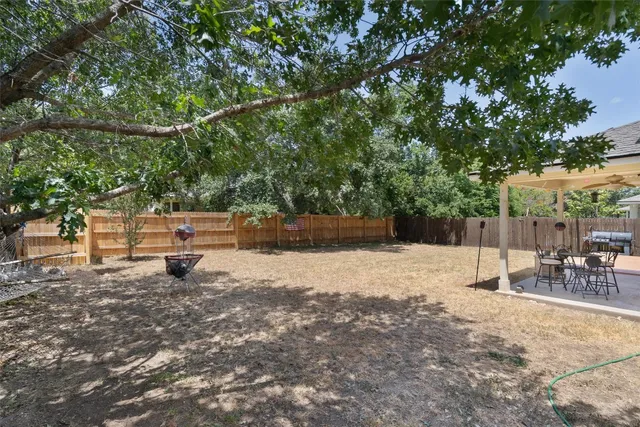 a view of a patio with table and chairs with wooden floor and fence