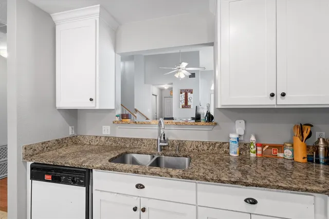 a kitchen with granite countertop a sink and cabinets