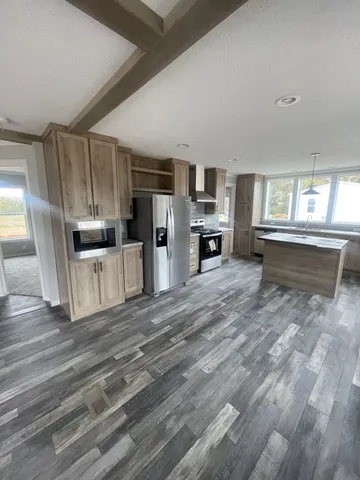 a kitchen with granite countertop a refrigerator stove top oven and sink