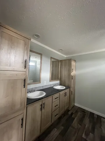 a bathroom with double vanity and a mirror