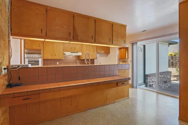 a kitchen with kitchen island a sink and a window