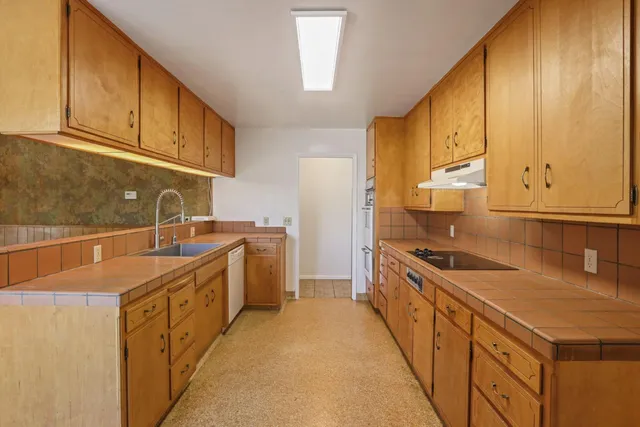 a kitchen with stainless steel appliances a sink a stove and cabinets