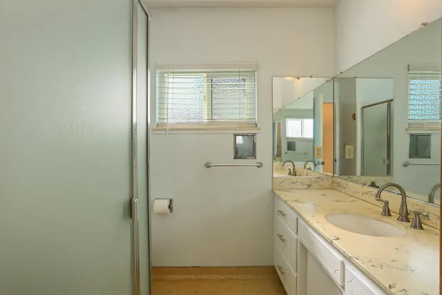 a bathroom with a granite countertop sink and a mirror