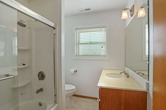 a bathroom with a sink a toilet a mirror and shower