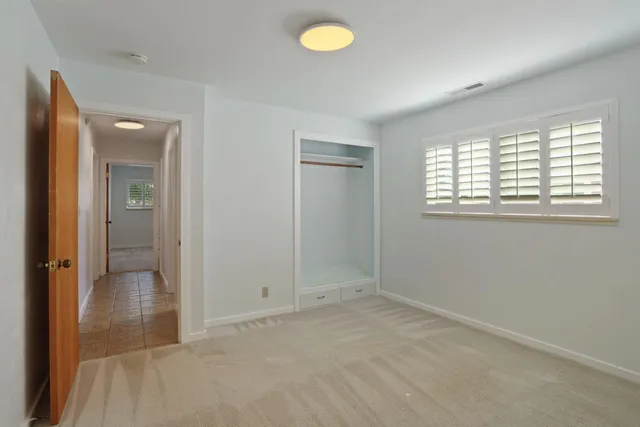 an empty room with windows and closet