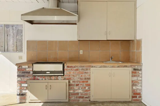 a view of a backyard with couches under an umbrella