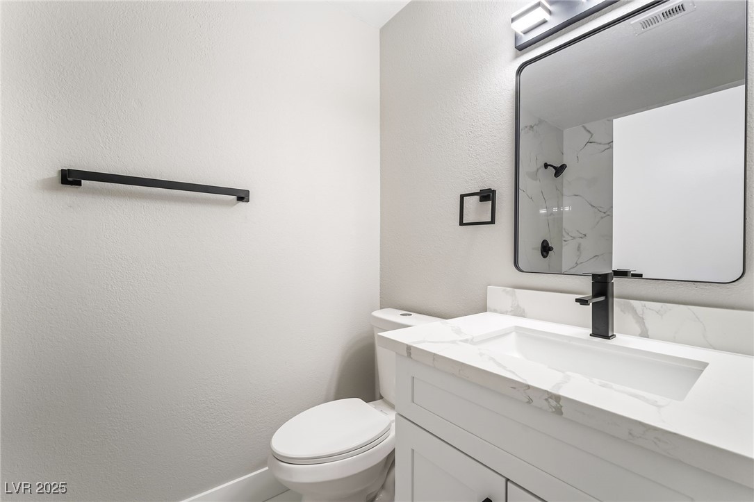 652 Red Lake Way Las Vegas, NV 89110 - Photo 14 of 66 Full bath with a marble finish shower, a textured wall, and vanity