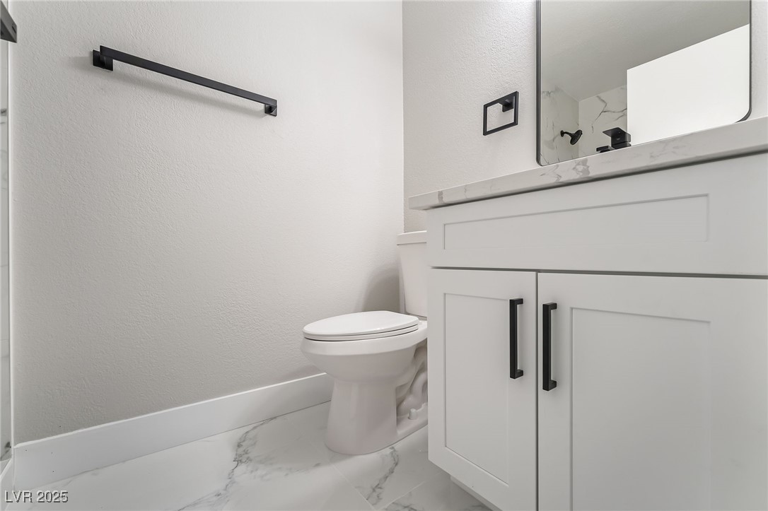 652 Red Lake Way Las Vegas, NV 89110 - Photo 15 of 66 Bathroom with marble look tiles, vanity, and a textured wall