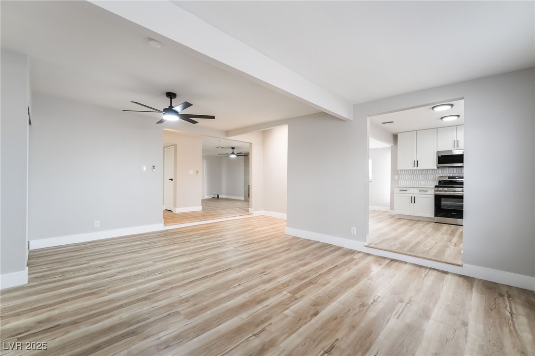 652 Red Lake Way Las Vegas, NV 89110 - Photo 18 of 66 Unfurnished living room with beam ceiling, light wood-style floors, and ceiling fan