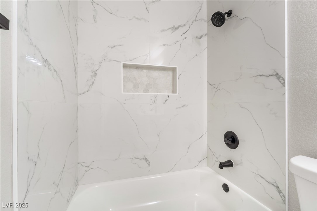 652 Red Lake Way Las Vegas, NV 89110 - Photo 28 of 66 Bathroom featuring a combined bath / shower with marble appearance and toilet