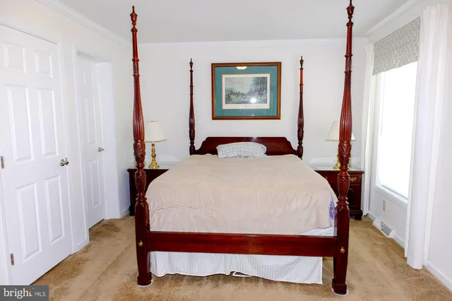 a bedroom with a bed and a painting on the wall