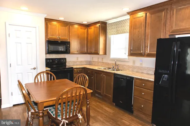 a kitchen with a table chairs sink and cabinets