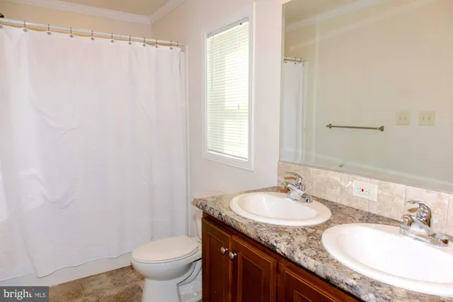 a bathroom with a granite countertop sink toilet and a mirror