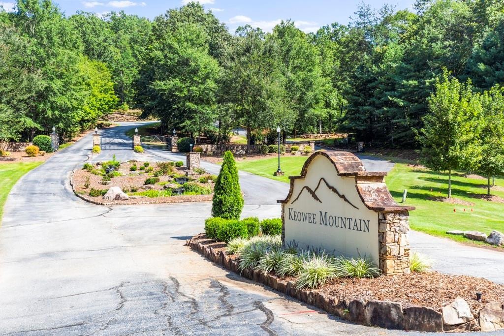 0 Gabriel Way Pickens, SC 29671 - Photo 1 of 14 The welcoming entrance features a stone-clad sign, guiding residents into a serene, tree-lined community.